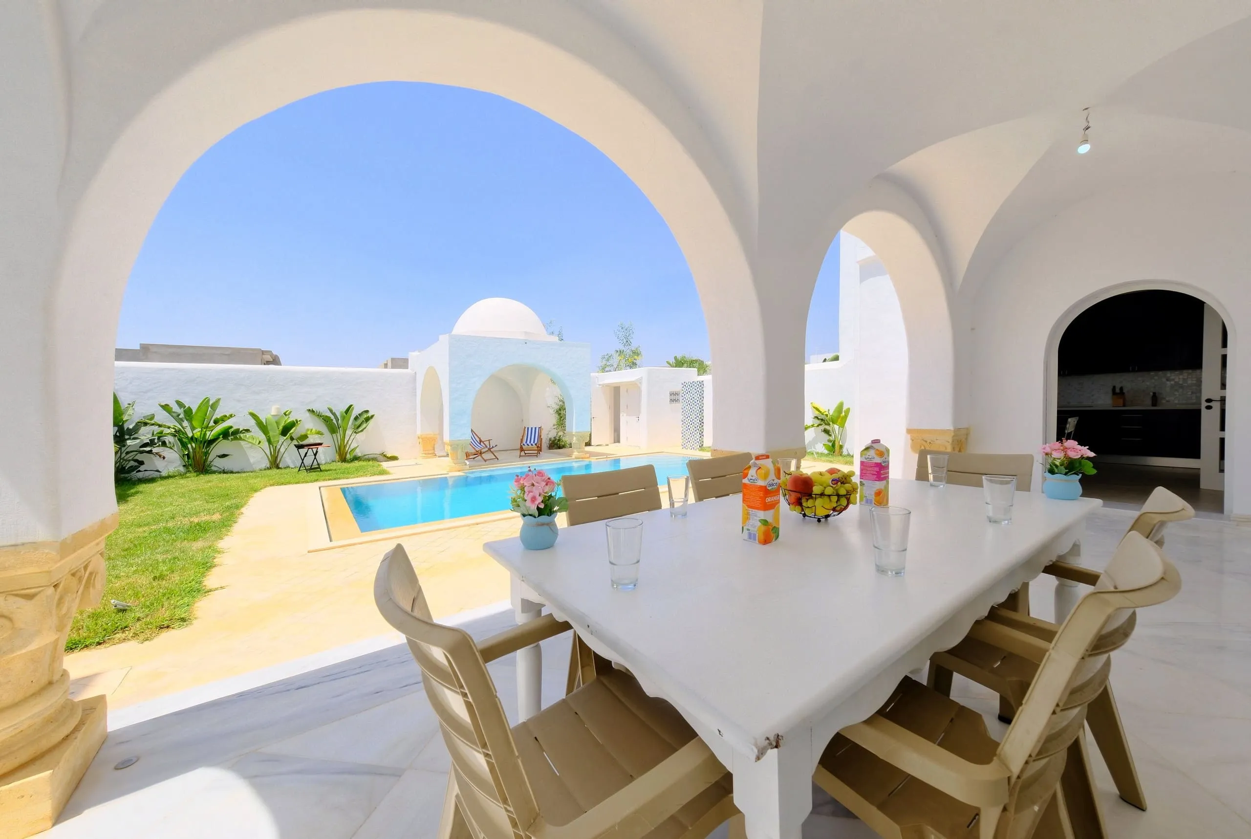 Dining table on the covered terrace facing the pool